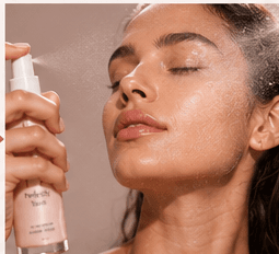 A model misting her face with The Rose Mist